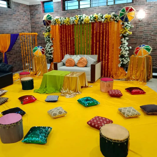 Vibrant Mehndi Stage Décor with Traditional Umbrellas & Floor Seating for a Festive Desi Celebration