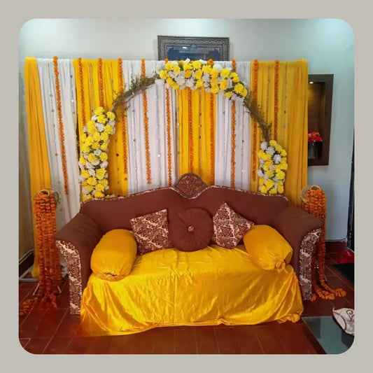 Traditional Yellow and White Mehndi Backdrop with Marigold Arch and Velvet Sofa